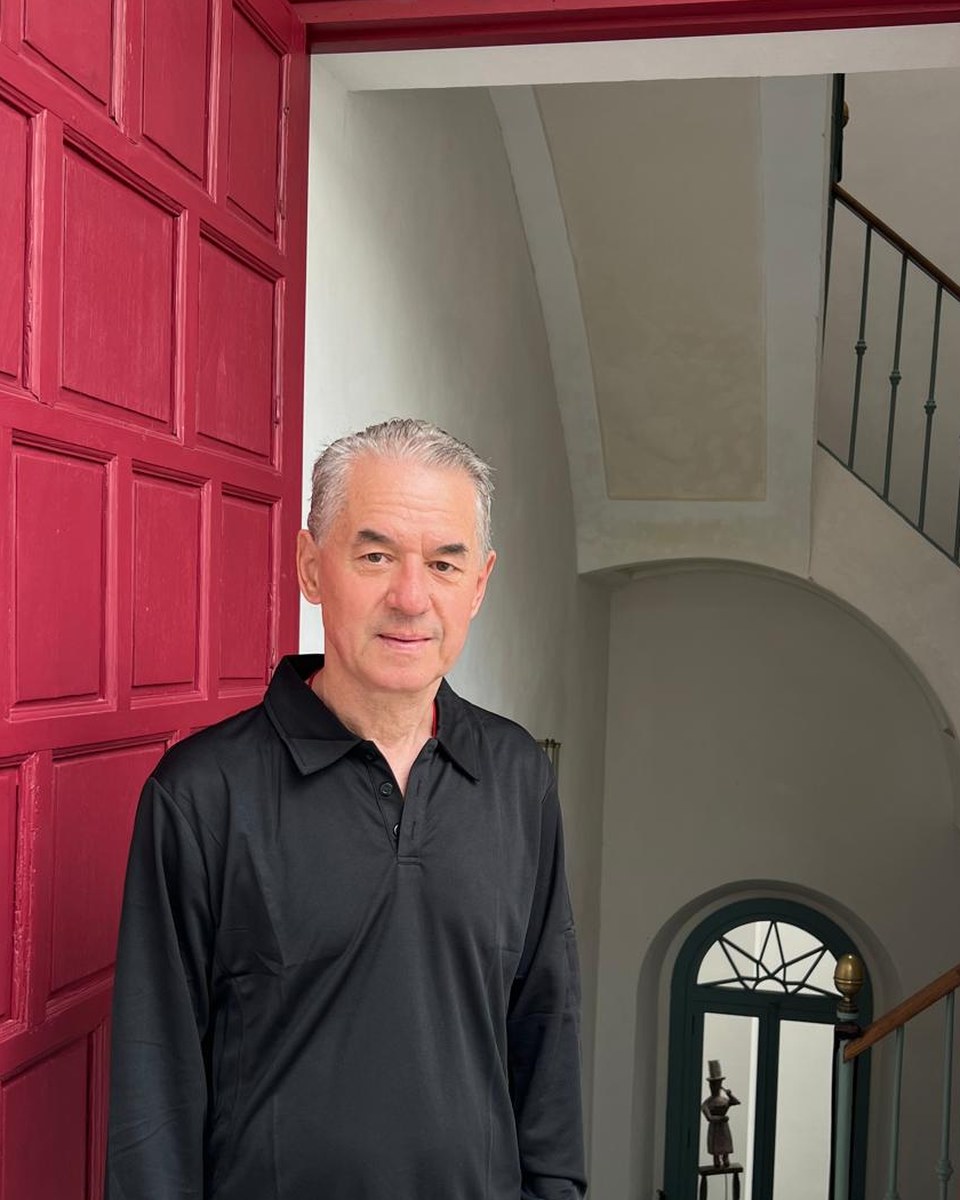 Johannes Maierhofer diante de uma porta vermelha